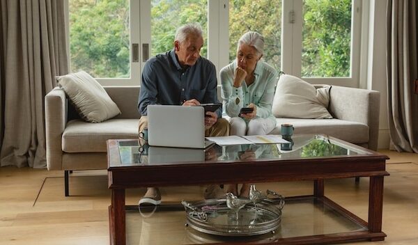 Active senior couple calculating bills in living room