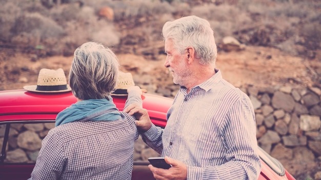Senior couple standing by car