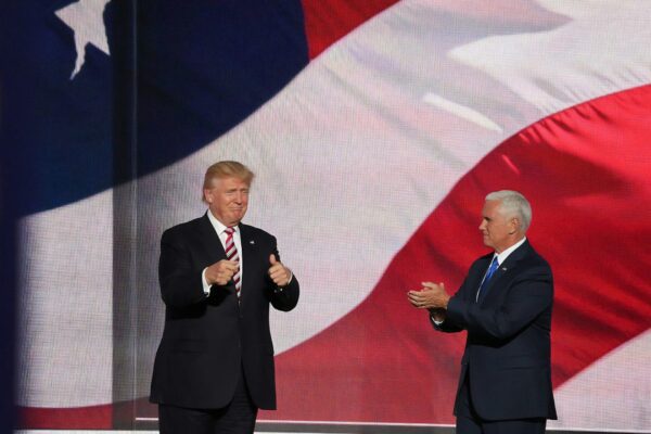 Donald Trump beside man in black suit