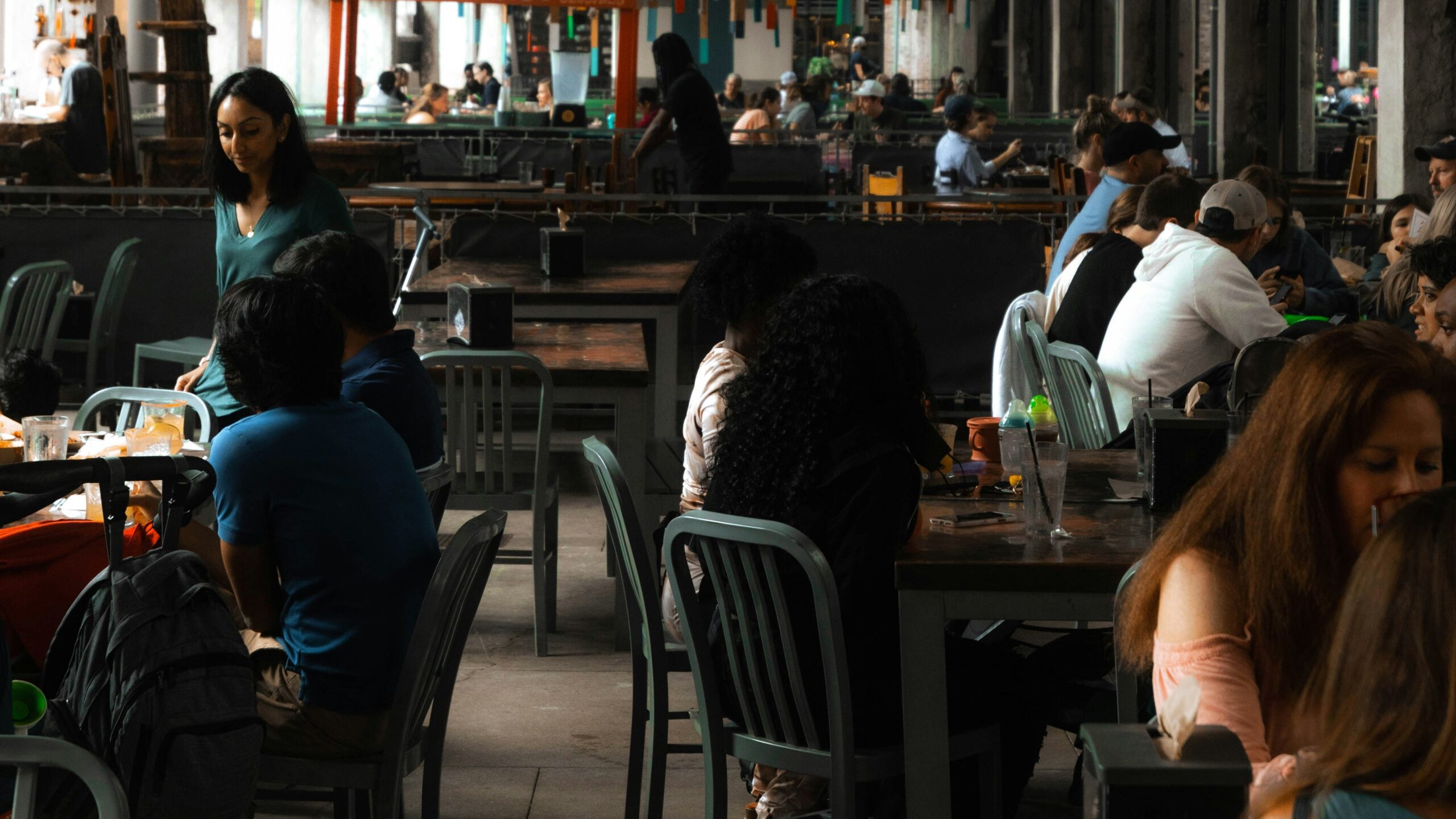 People dining in a spacious industrial-style restaurant.