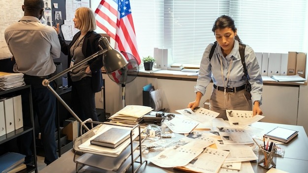 Young female fbi agent looking through criminal profiles of gang members