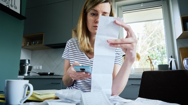 Woman calculating payment bill at home