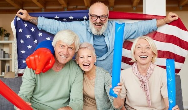 Portrait of excited senior friends cheering together for their American football team at home