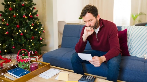 Man anxiously tallying up his holiday spending and clutching a receipt
