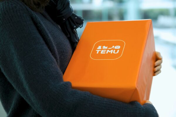 Woman holding an orange temu package