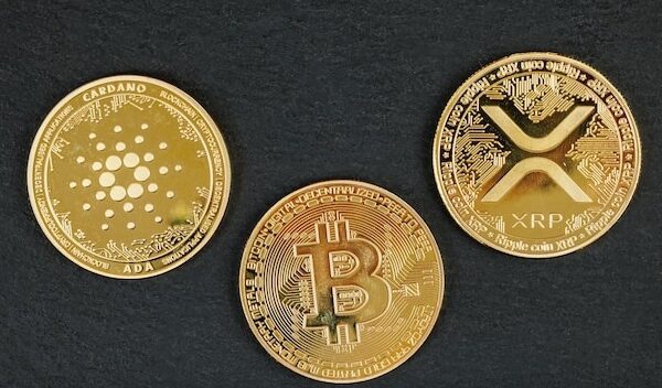 Gold cryptocurrency coins Bitcoin Cardano and Ripple on a dark background