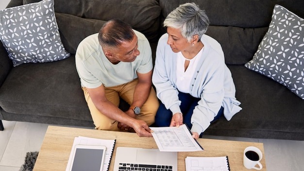 Senior couple tax documents and laptop in home living room for discussion planning and finance Elderly man old woman and paperwork for financial compliance in top view lounge sofa and retirement