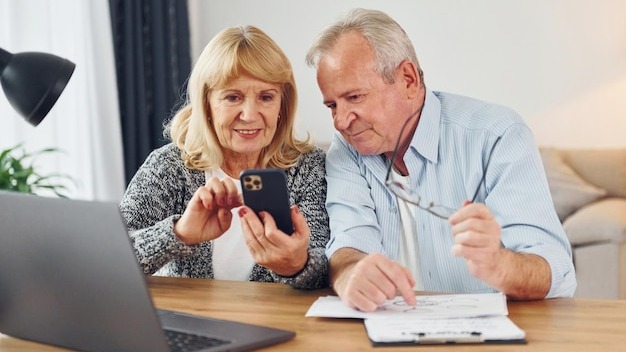With laptop on the table Senior man and woman is together at home