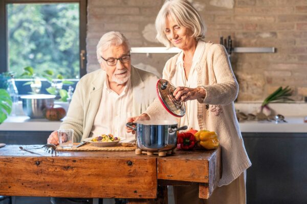 Elderly couple cooking together in a modern kitchen.