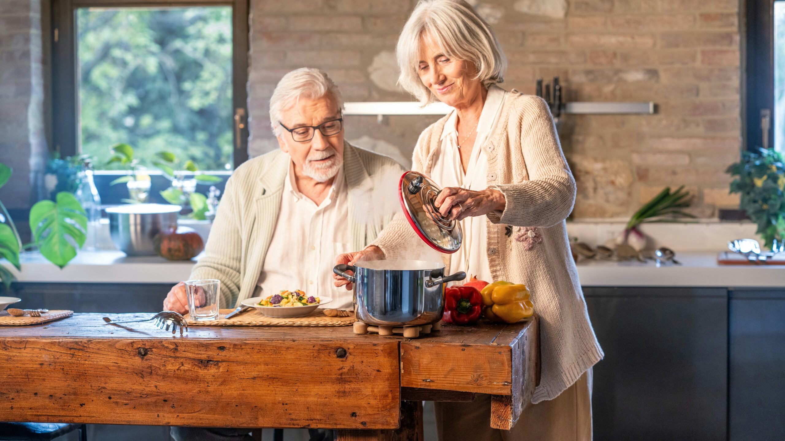 Elderly couple cooking together in a modern kitchen.