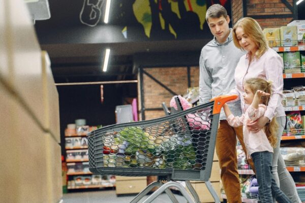 A joyful family with a child shopping together in a supermarket, bonding over groceries.