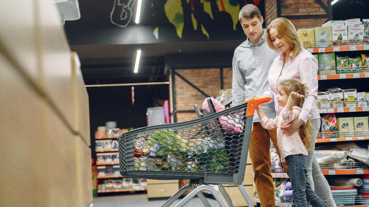 A joyful family with a child shopping together in a supermarket, bonding over groceries.
