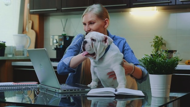 Blonde woman making online video call to her relatives to show a small bulldog