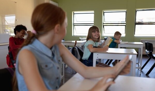 Schoolgirl sitting at a desk using a tablet computer