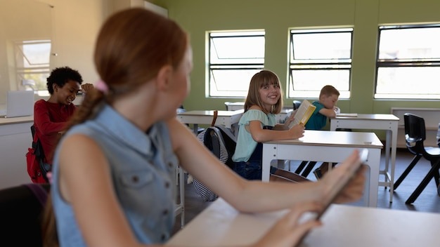 Schoolgirl sitting at a desk using a tablet computer