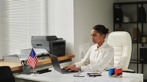 Visa center employee concentrating on her online work on laptop she typing data of documents