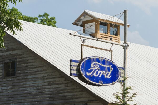 A blue ford sign sitting on the side of a building