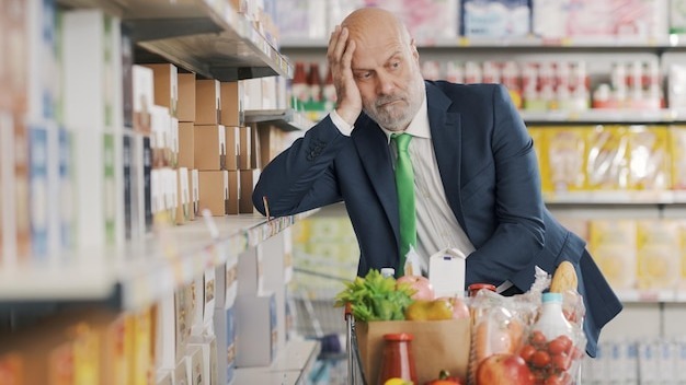 Tired confused man at the supermarket
