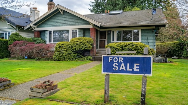 Home for sale with a sign with written FOR SALE in front of a house real estate sales concept