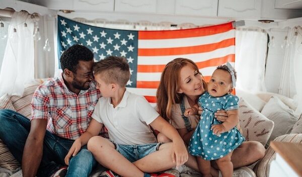 Cheerful family sitting against american flag