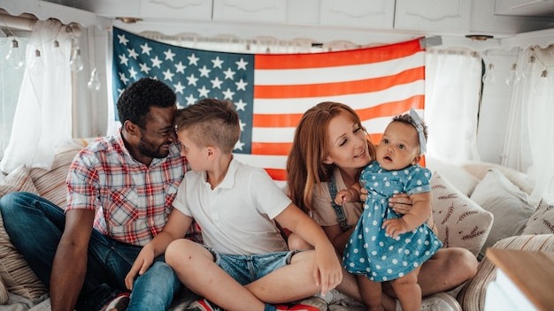 Cheerful family sitting against american flag