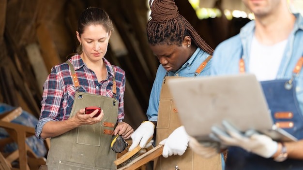 Portrait of carpenter male worker standing with laptop in workshop
