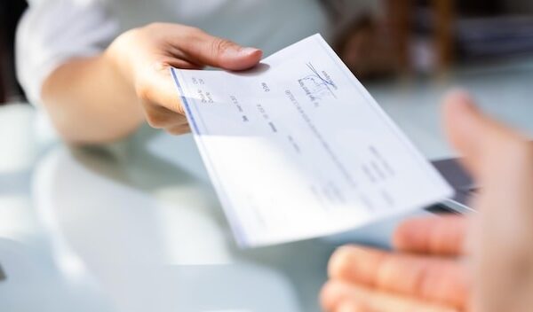 Hand Giving Payroll Compensation Paycheck