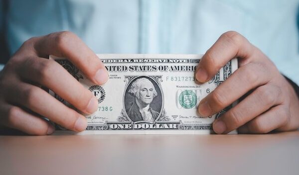 Businessman holding USD dollar banknote with stock market trading graph for Dollar currency is the main exchange and transfer money in the world