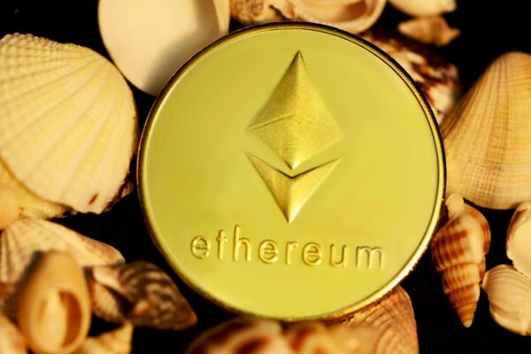 a gold ether coin surrounded by shells