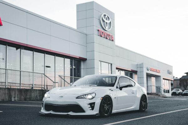 White Toyota sports car parked at a dealership, showcasing style and performance.