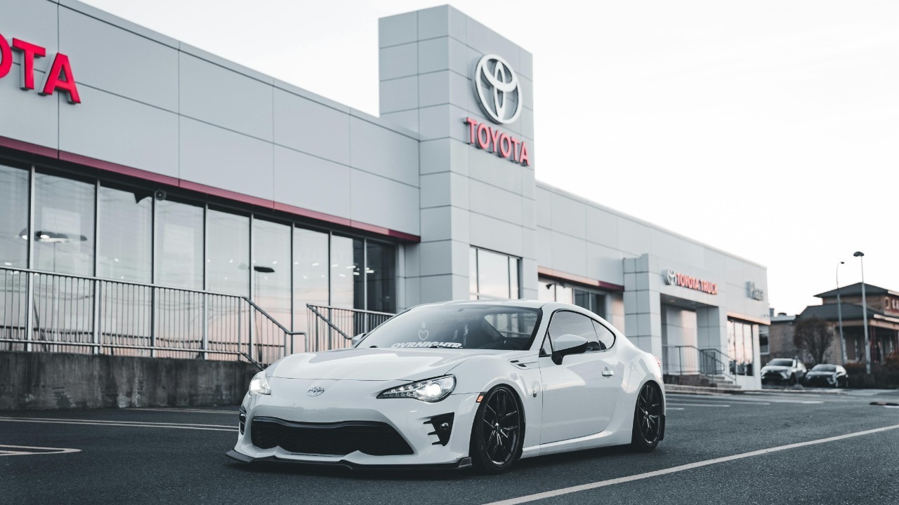 White Toyota sports car parked at a dealership, showcasing style and performance.