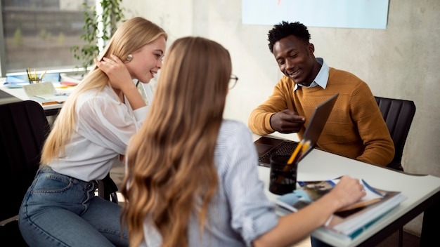 Medium shot people looking at laptop