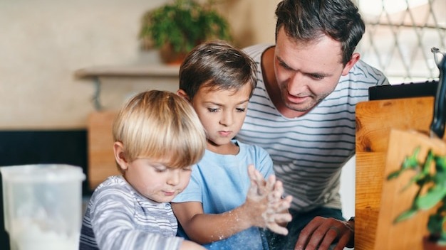 Baking playing and father with children in kitchen with ingredients for learning bonding and recipe Family home and dad with young boys with flour to bake cookies biscuits and treats together