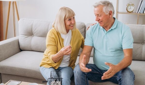 Group of four cheerful senior people playing bingo game in nursing home