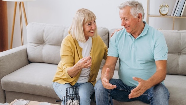 Group of four cheerful senior people playing bingo game in nursing home