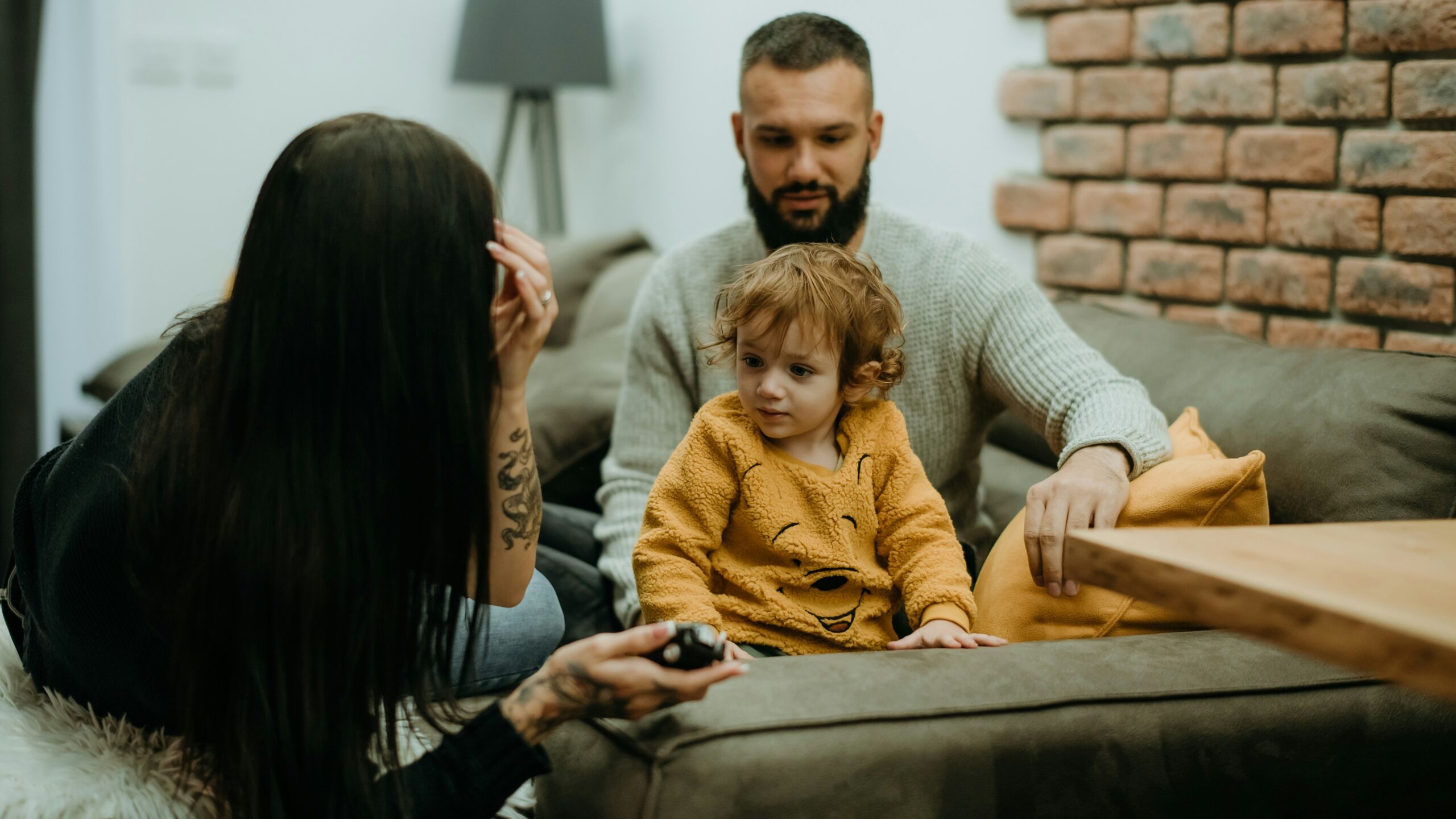 a man sitting on a couch next to a little girl