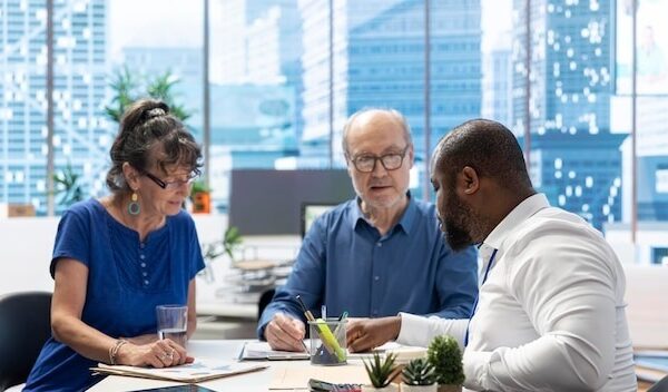 Senior couple discussing with a financial advisor to choose retirement plans