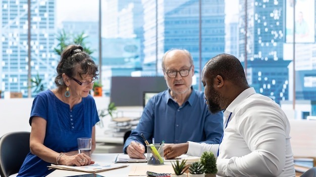 Senior couple discussing with a financial advisor to choose retirement plans