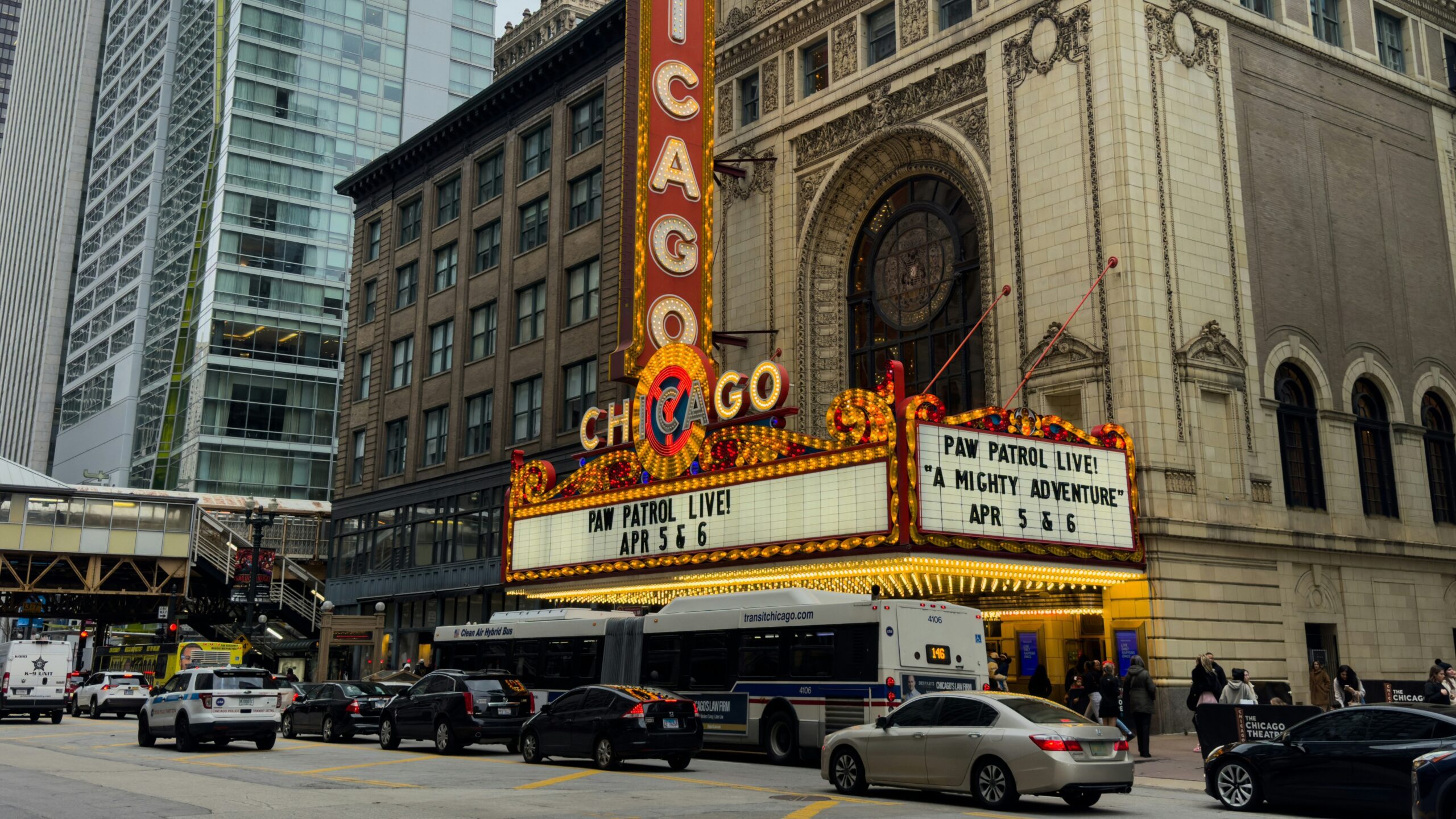 The chicago theatre is busy on a city street.