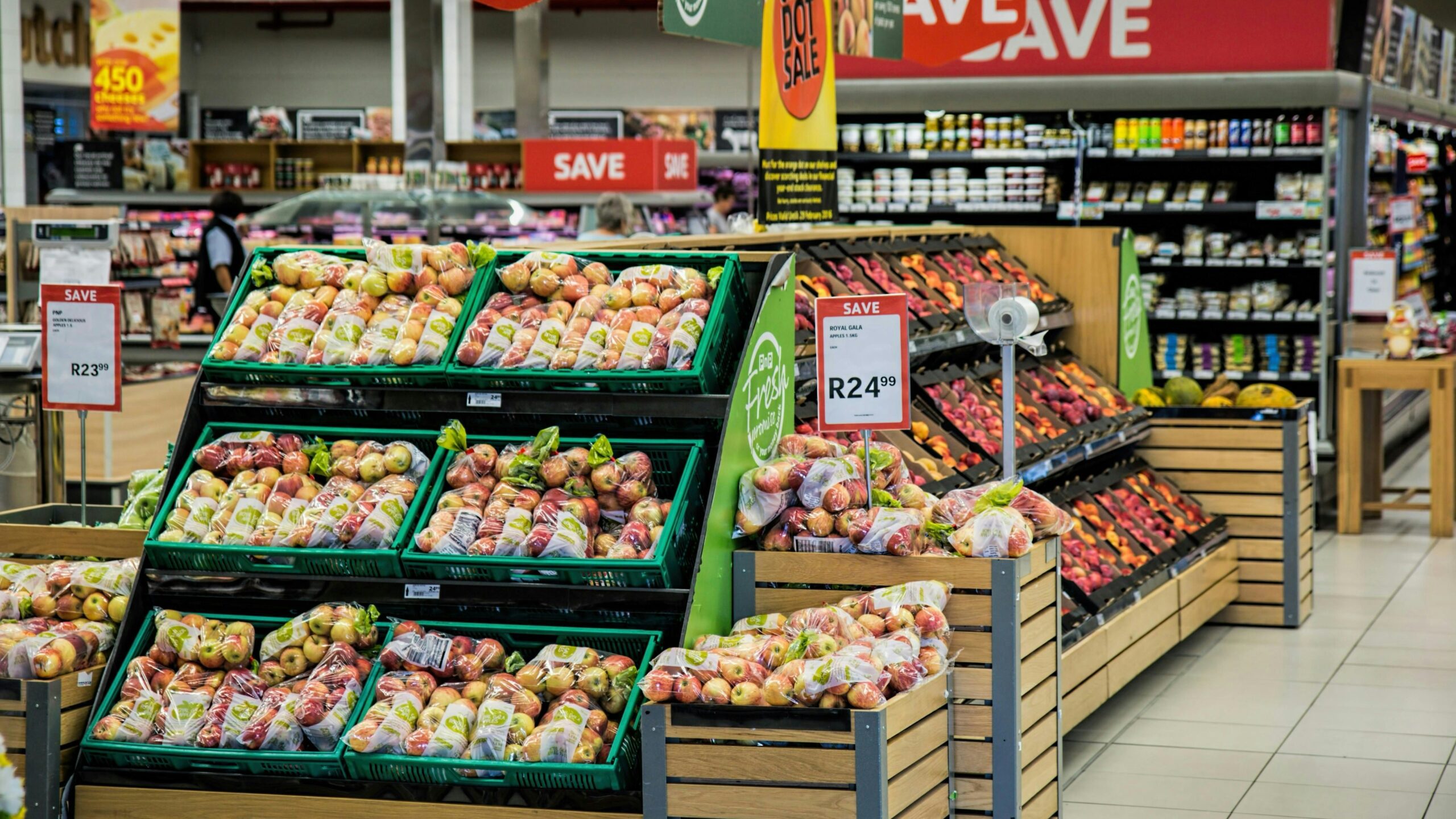Apples and other produce are displayed in a supermarket.