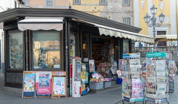 Newsagents shop exterior newsstands full of foreign daily newspapers
