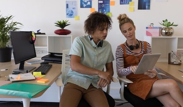 Businesswomen talking together using tablet pc in the office