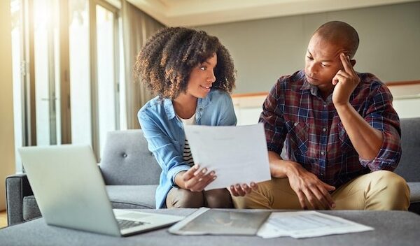 What do you think of this idea Shot of a focused young couple working on a laptop and doing paperwork together while being seated on a couch at home
