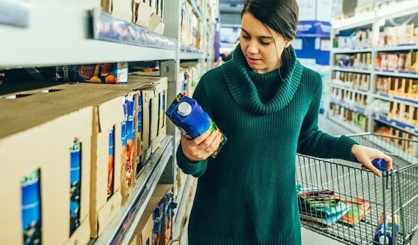 woman in store read ingredients of juice grocery shopping copy