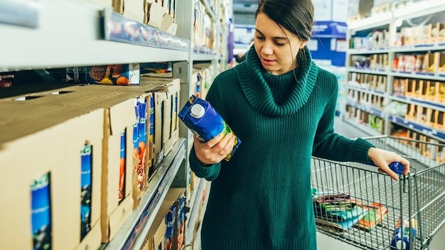 woman in store read ingredients of juice grocery shopping copy