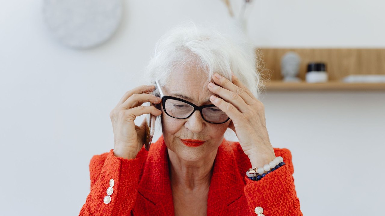 Older woman looking stressed while on a phone call